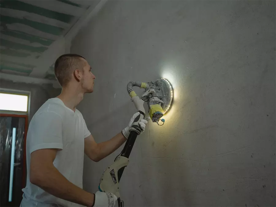Interior polished concrete in Bolton Estates with a worker using a polishing machine