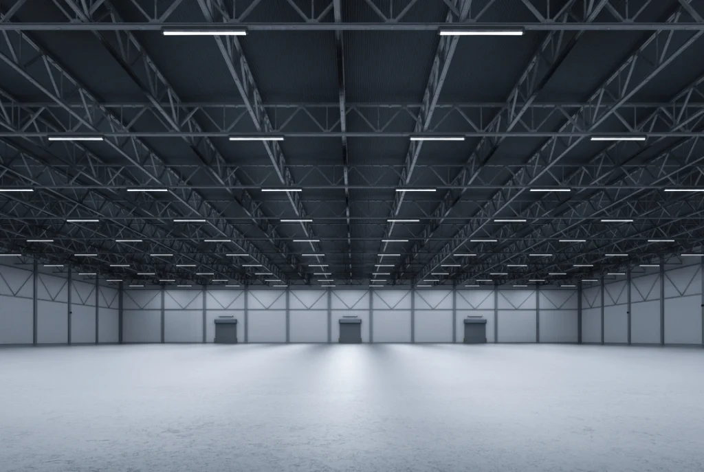 Bright, empty industrial warehouse with seamless, light-reflective finished cement flooring houston.