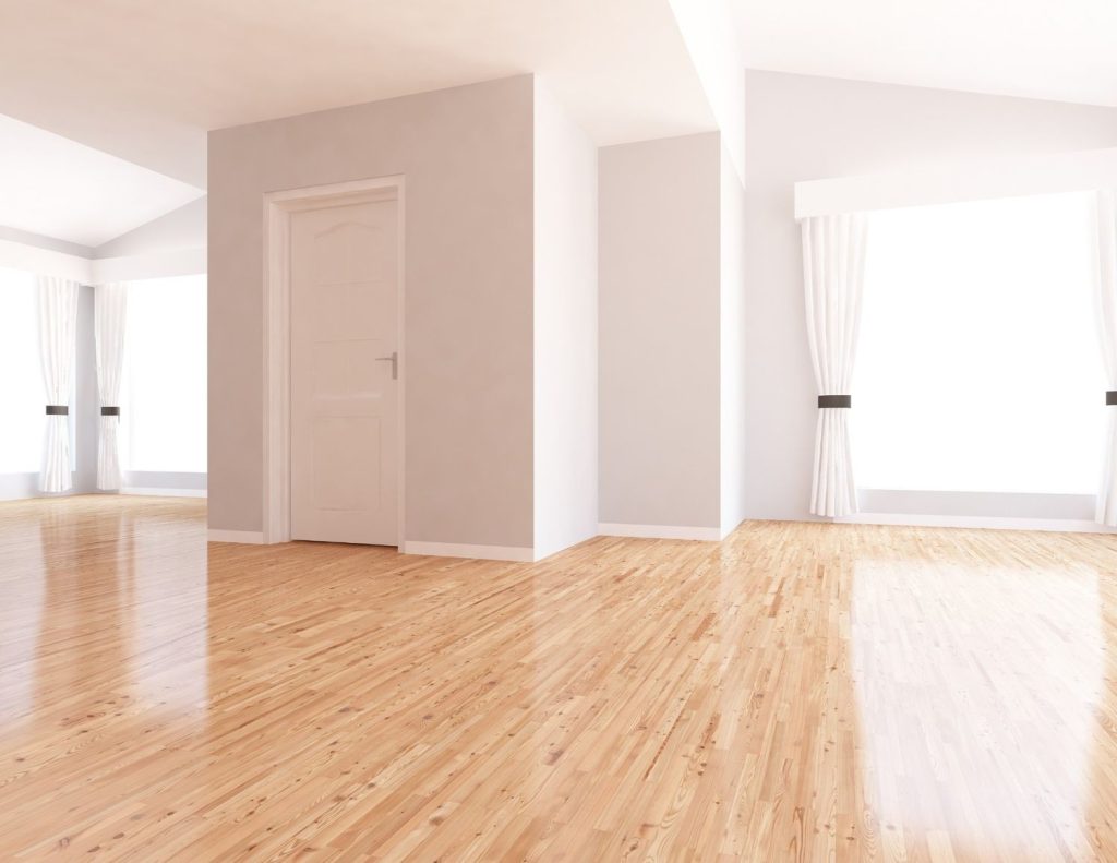 Bright room with large windows and shiny, natural wood-toned plank-style refinished concrete flooring Houston.