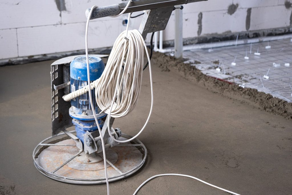 Electric power trowel smoothing cement for durable, high-shine cement polishing flooring Houston projects.