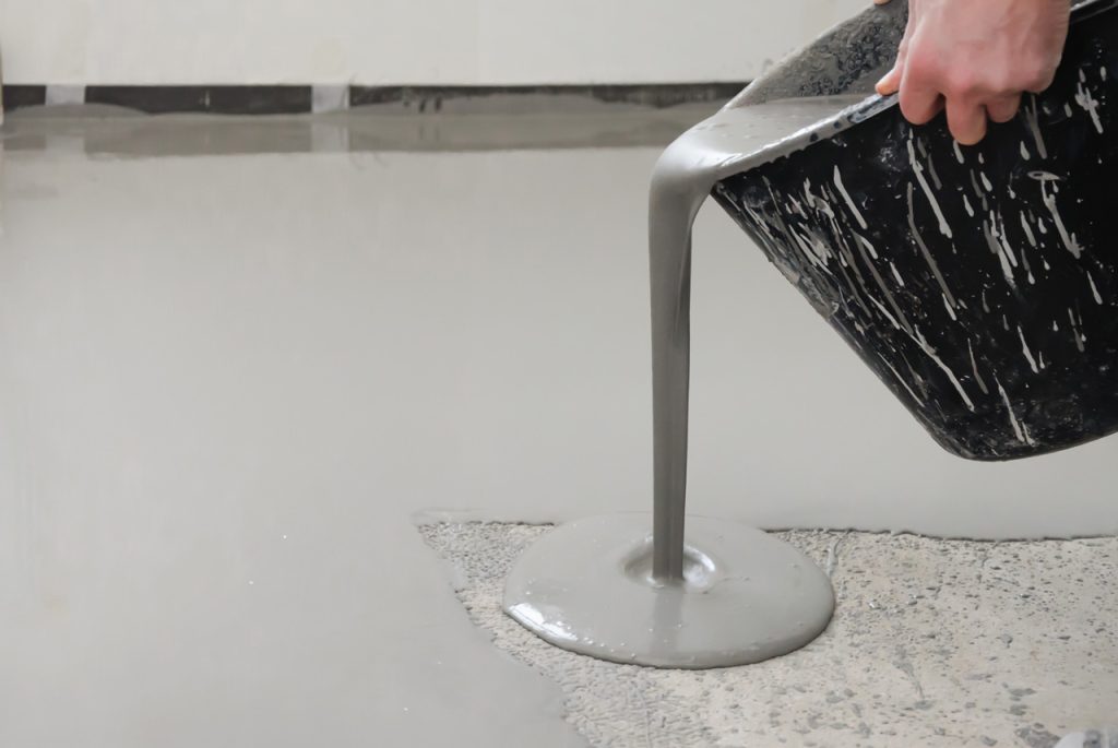 Close-up of liquid compound being applied to create a smooth, durable finished cement flooring Houston installation.