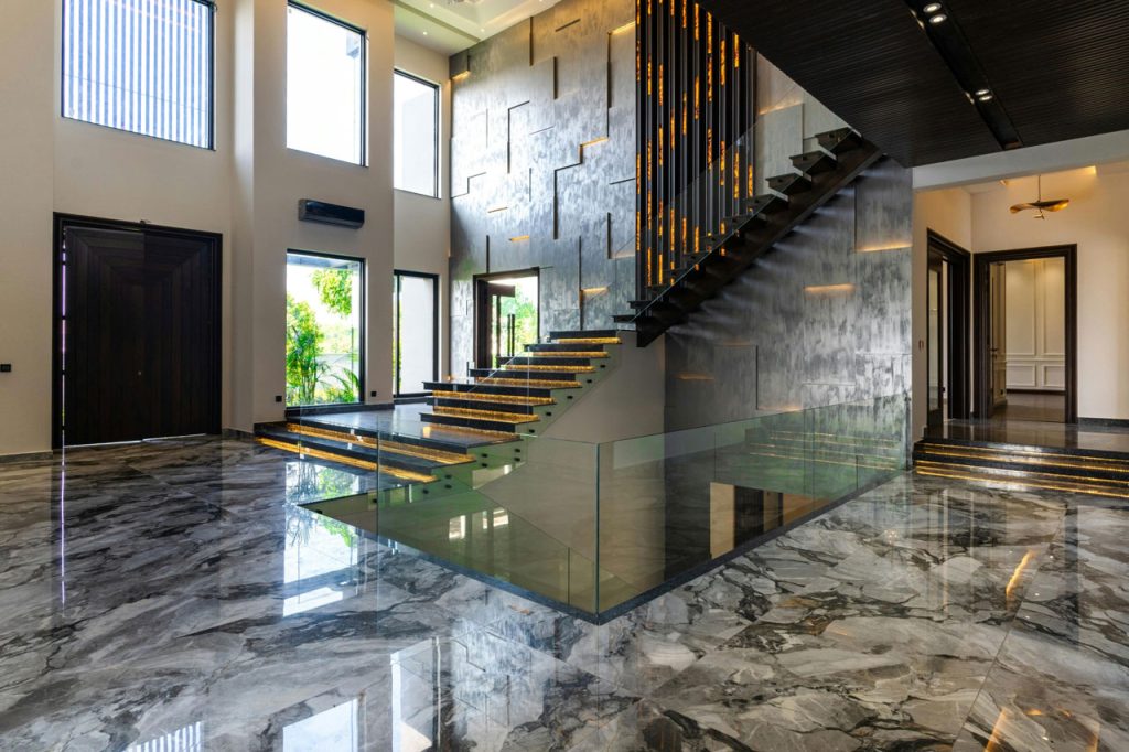 Modern grand foyer with grey marbled shiny cement flooring Houston, showcasing a reflective and durable finish.