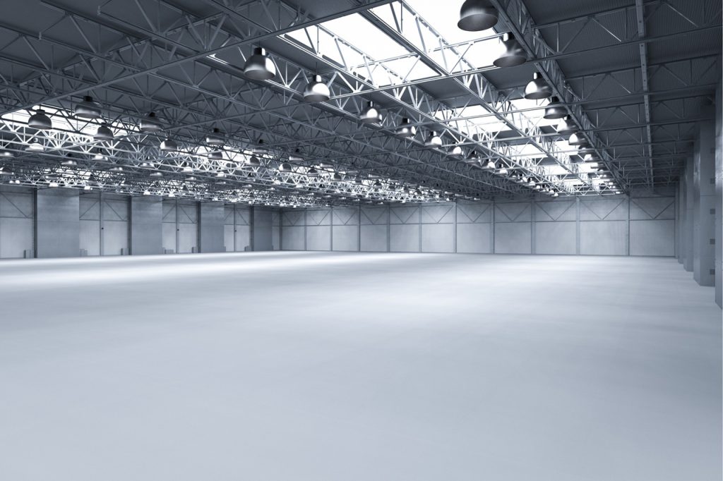 Seamless refinished cement flooring Houston showroom with industrial lighting and a modern, polished grey finish.