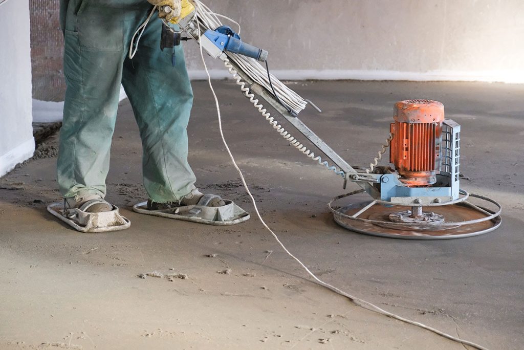 Heavy duty equipment finishing a smooth surface for refinished concrete flooring Houston commercial interiors.