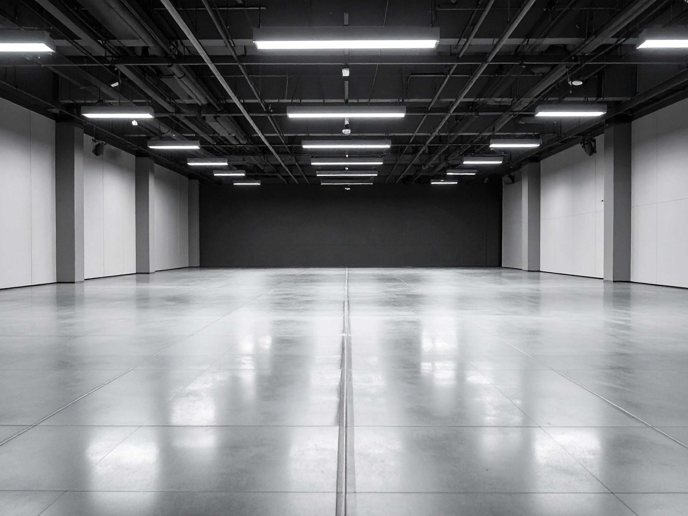 Shiny cement flooring Dallas in a modern commercial event space with polished concrete floors reflecting overhead lighting