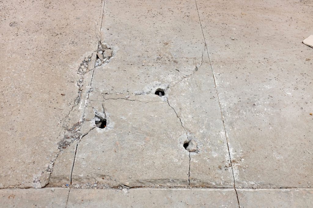 Multiple pits and surface deterioration on finished concrete flooring Houston slabs showing signs of aging and wear.