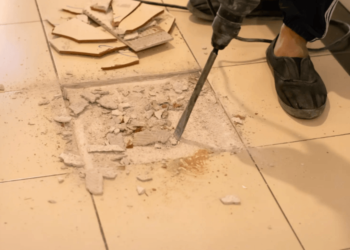 Floor removal service Houston expert using a jackhammer to break up and remove old ceramic tile and thinset.