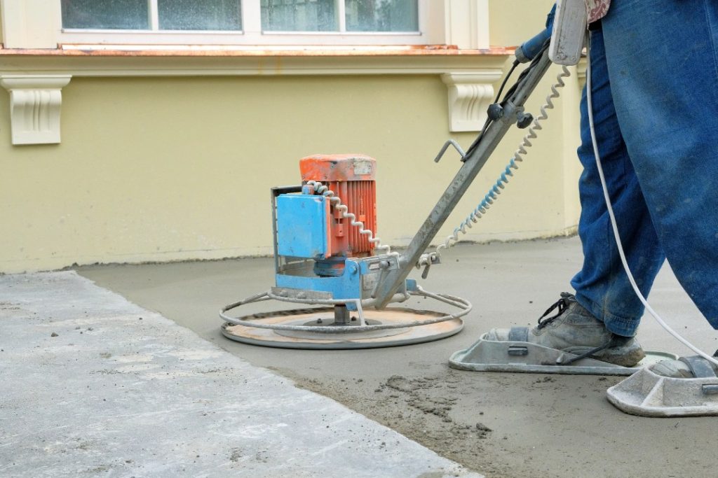 Contractor uses electric walk-behind trowel for shiny cement flooring Houston results on an exterior porch slab.