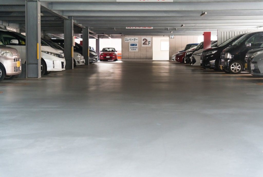 A clean, multi-level parking garage with durable polished concrete floors, the work of expert polished concrete contractors houston.