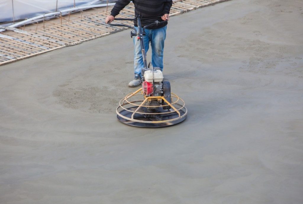 This power trowel creates a smooth finish on a new concrete floor, the expert service of polished concrete contractors houston.