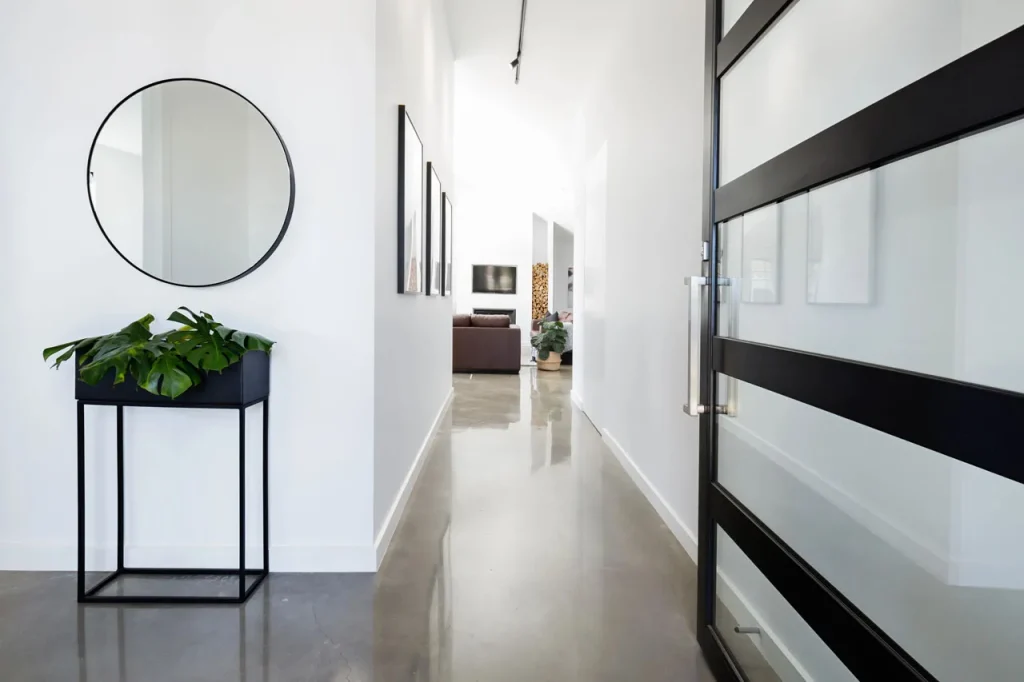 Reflective hallway floor with minimalist decor by an expert polished concrete company Houston contractor.