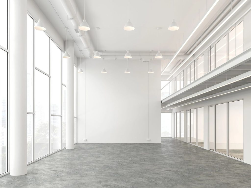 Modern office with polished concrete floors by Houston concrete polishing services, featuring large windows and sleek design.