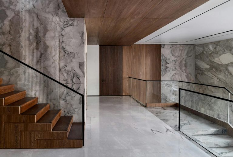 Luxury marble and wood grand staircase design within the upscale Quail Valley Thunderbird Patio Homes community interior.