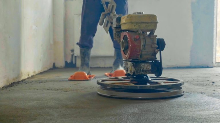 Professional polished cement contractors Houston using a power trowel to smooth and level a new concrete floor.