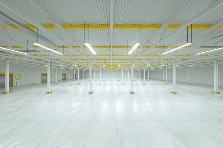 Bright modern distribution center showcasing high-gloss refinished concrete flooring Houston and white steel beams.