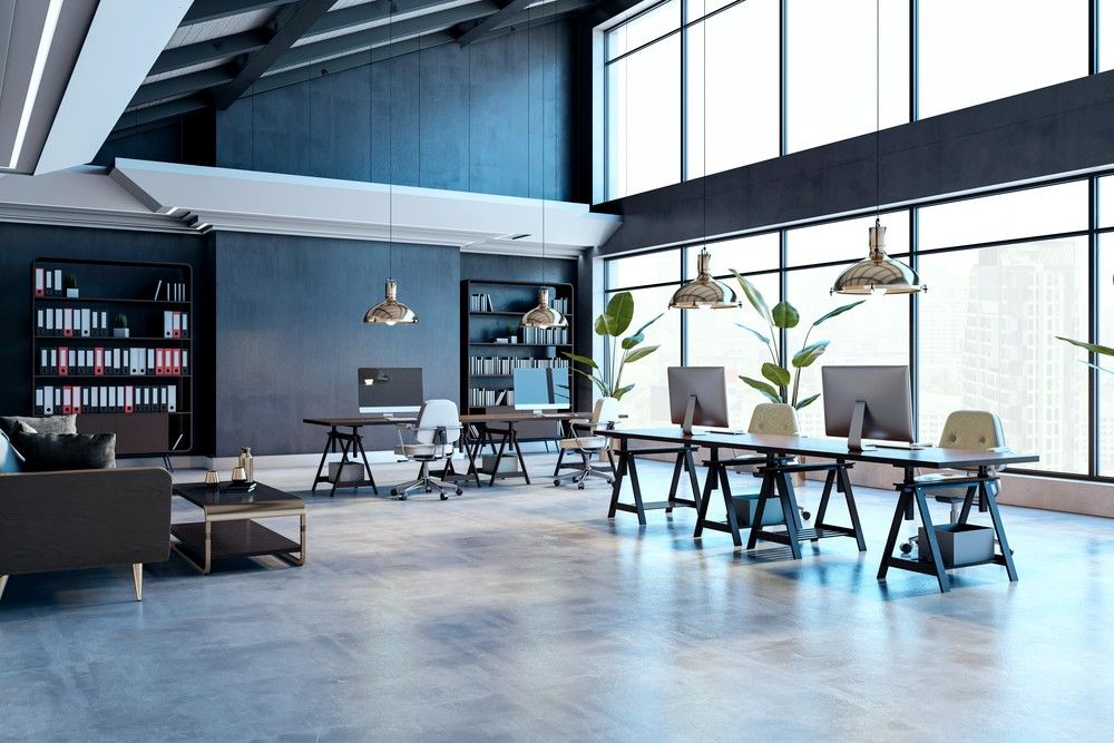 A large, open modern co-working office space with workstations over a clean refinished concrete flooring Houston.